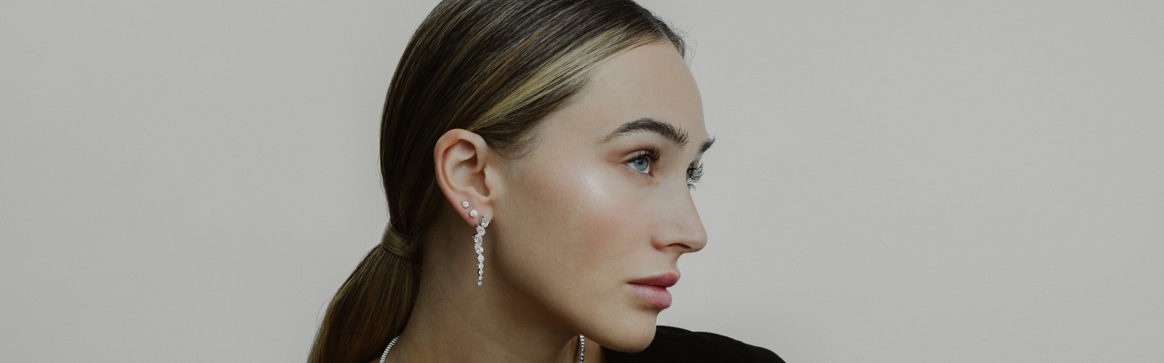 Nahaufnahme eines Models, dass die EDEN CHANDELIER Ohrringe aus 585/- Weißgold mit gezüchteten Diamanten trägt.