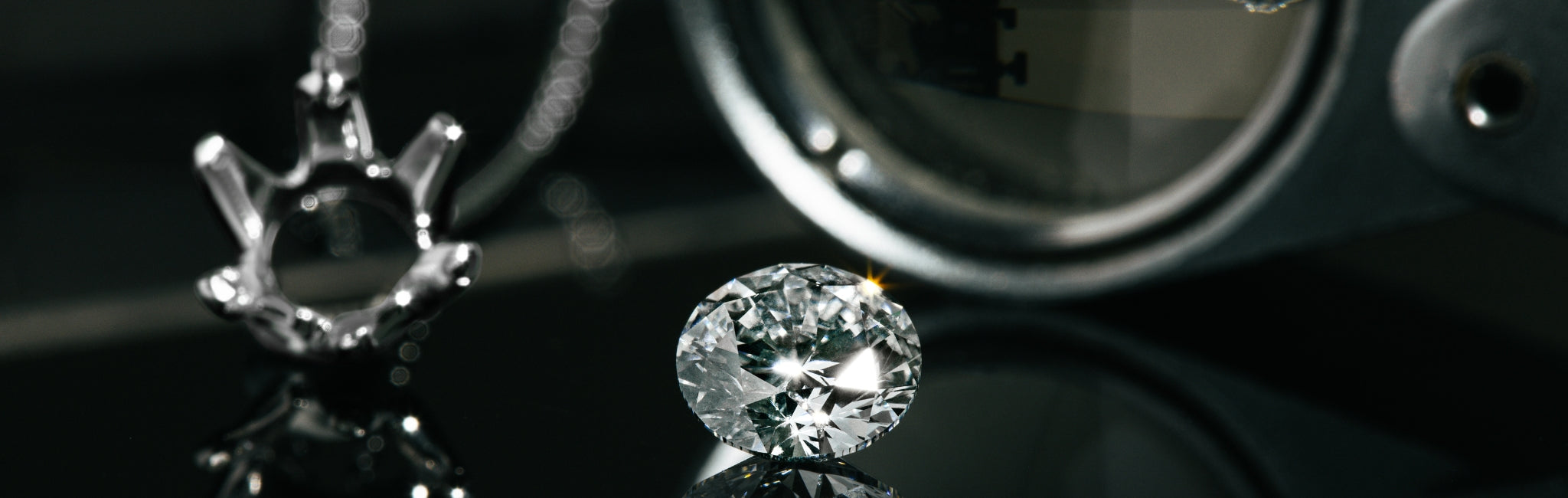 Funkelnder Diamant in Nahaufnahme auf schwarzer, spiegelnder Oberfläche, daneben eine leere Krappenfassung aus Metall und eine Lupe im Hintergrund.
