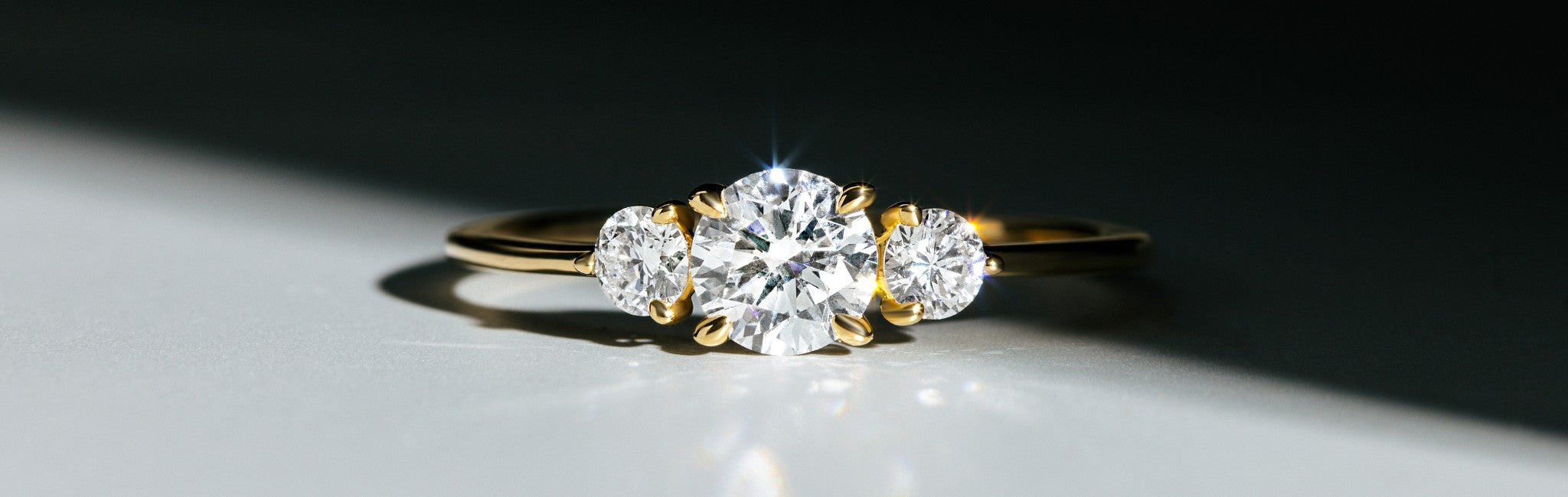 Trilogy Ring DS3028G in Gelbgold vor dunklem Hintergrund