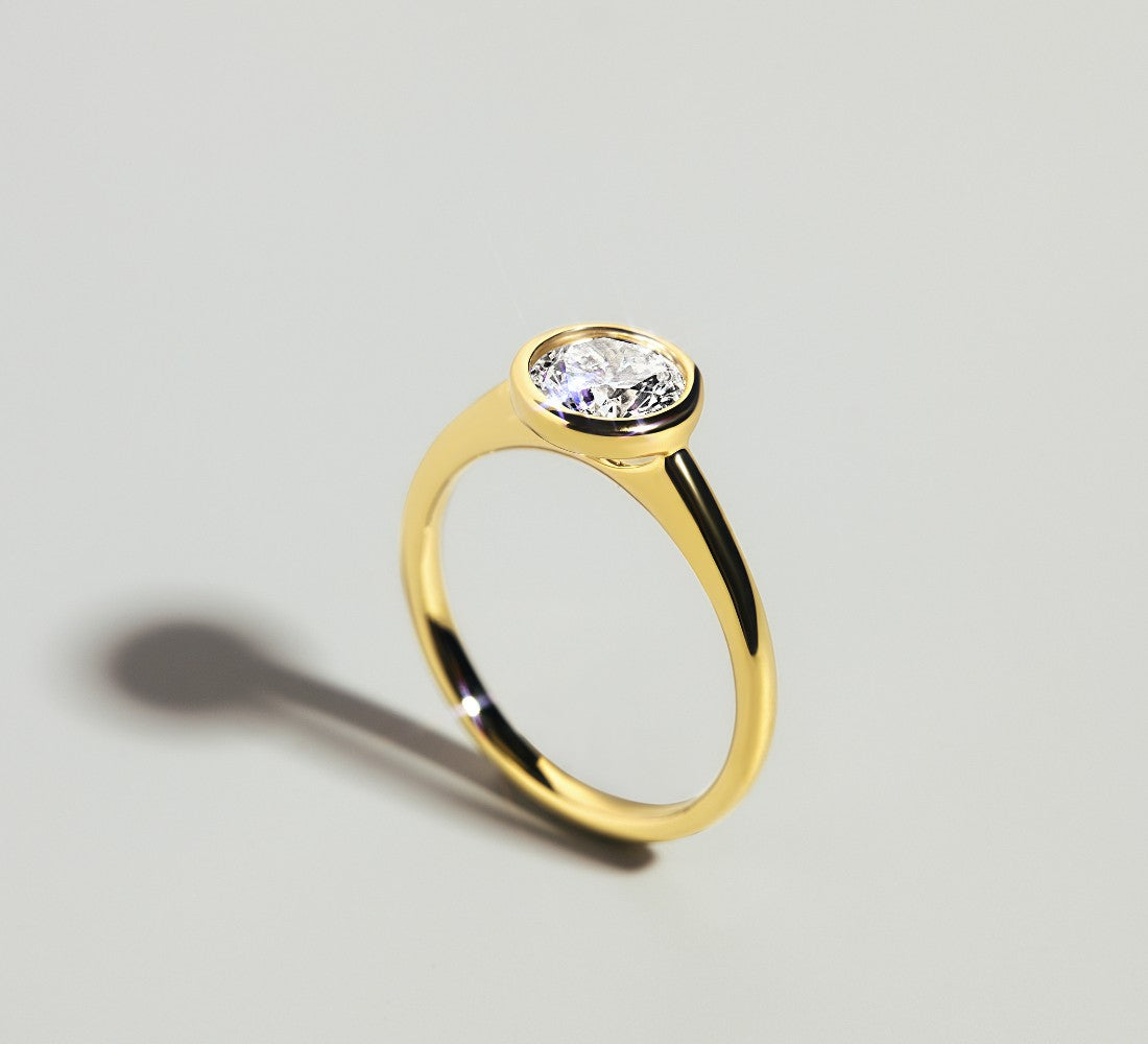 Ring aus Gelbgold mit funkelndem Solitär-Diamant DS1024G in Zargen-Fassung auf hellem Untergrund.